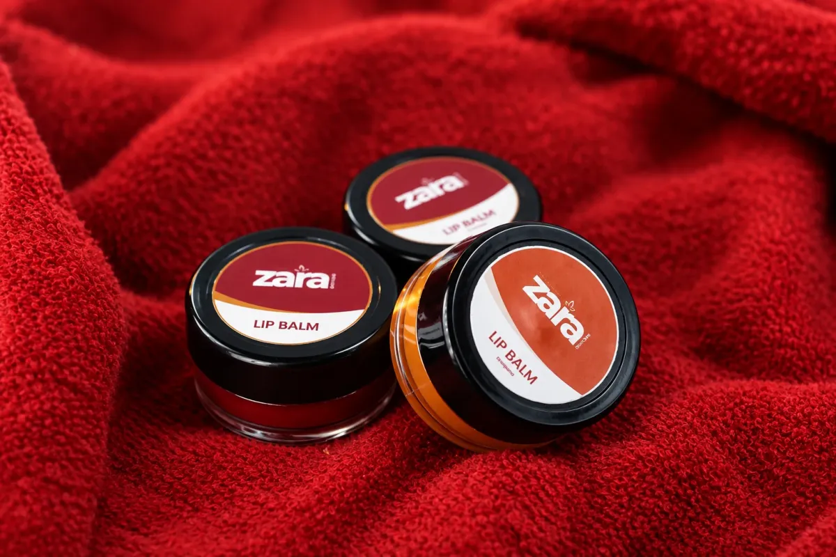 Three Zara lip balm jars on red cloth